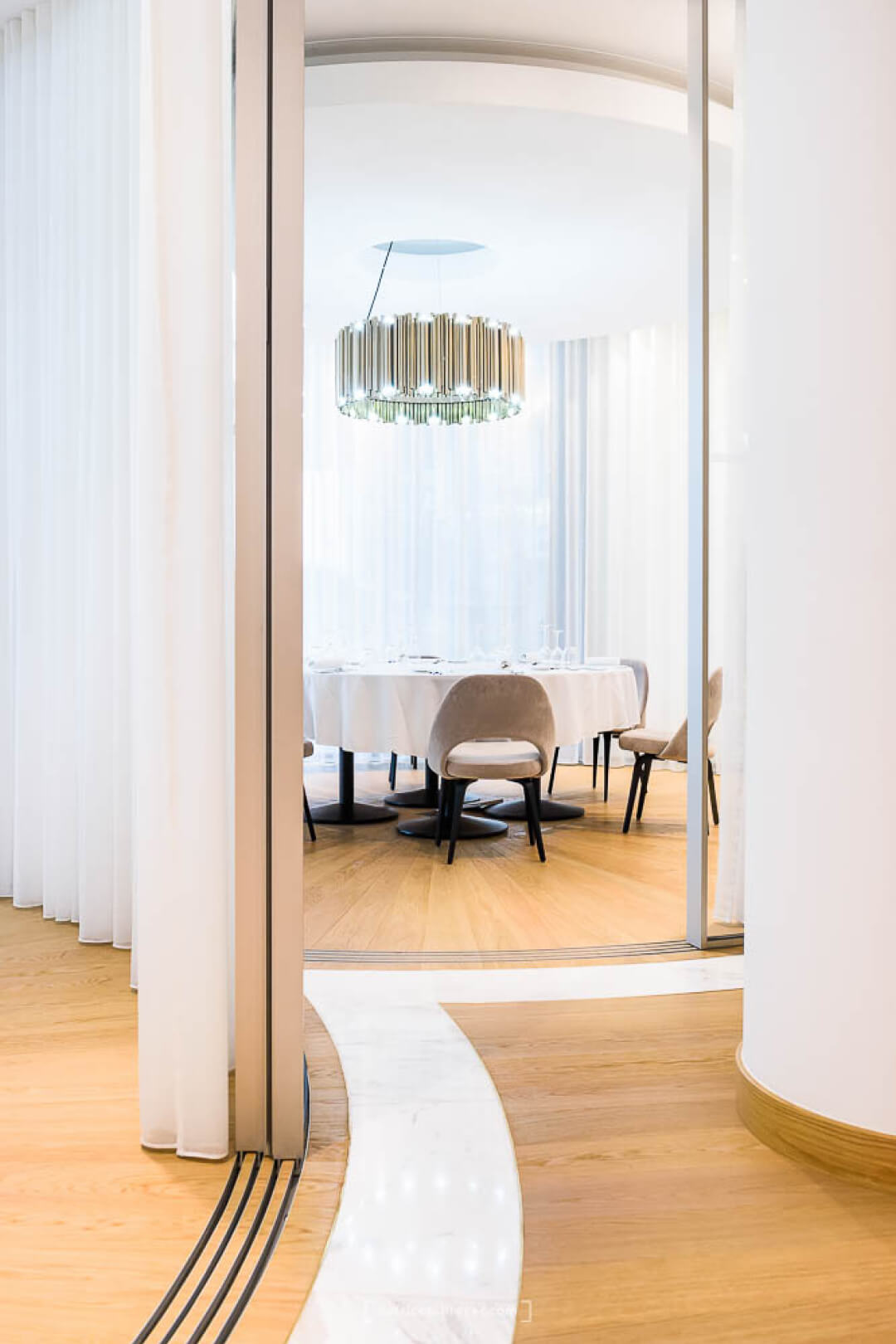 Salas VIP de Piaget que muestran hojas correderas curvadas de Vitrocsa que forman espacios circulares